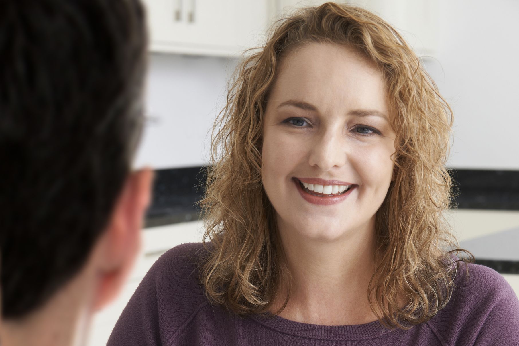 Smiling woman talking to doctor