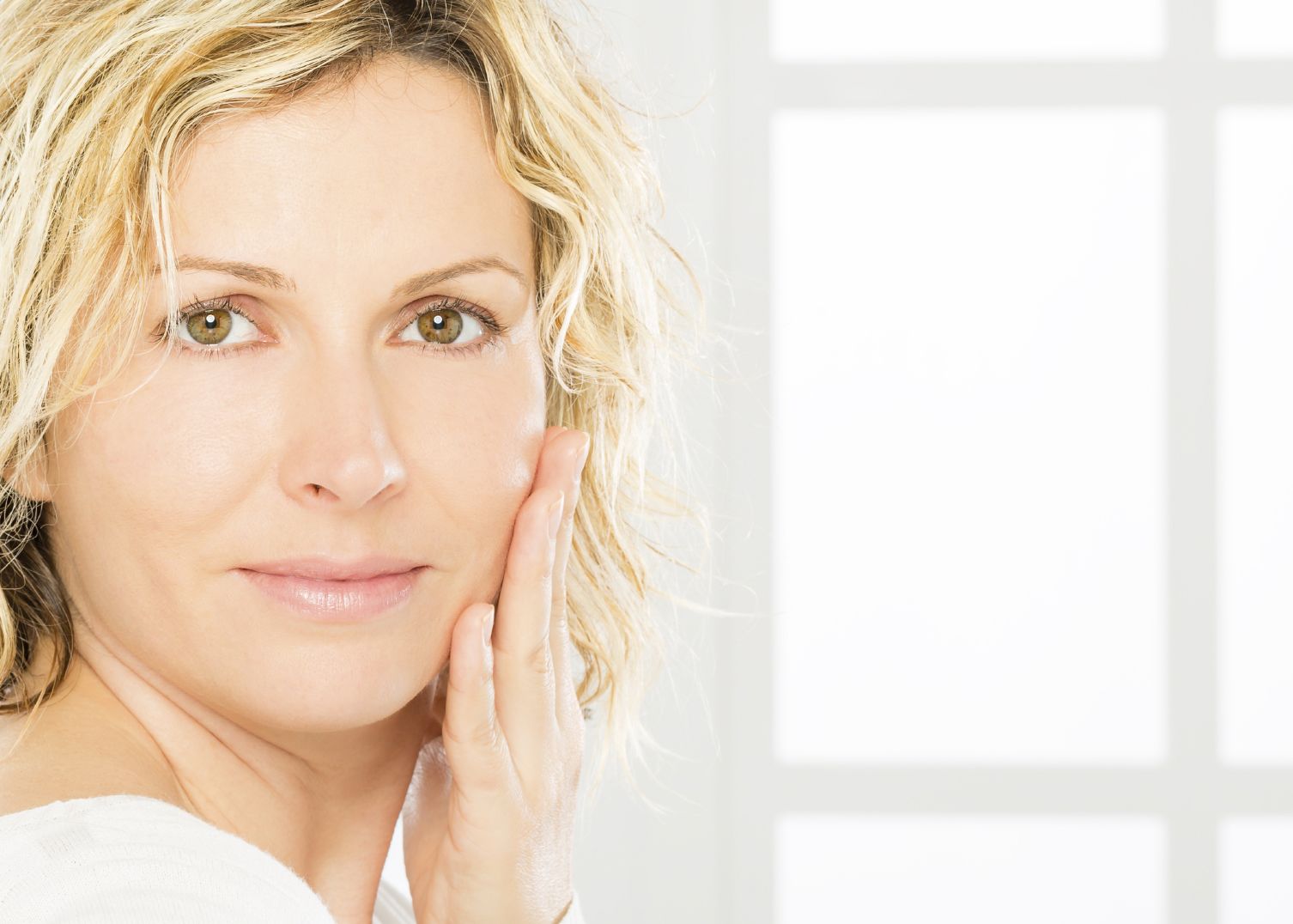 Attractive blonde woman holding the side of her face