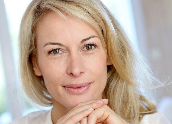 Attractive blonde woman posing with hands under chin