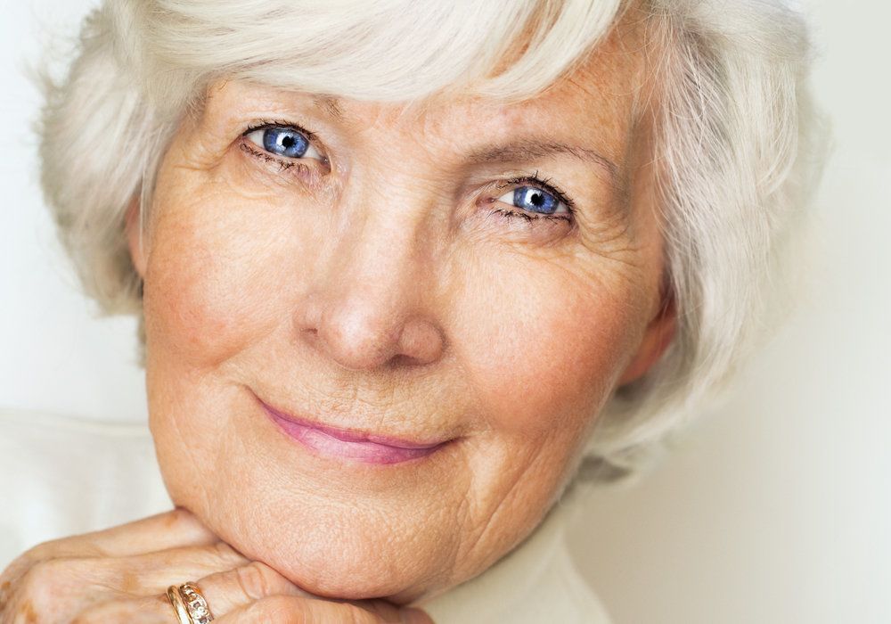 Woman shows her improved eyes after eyelid surgery